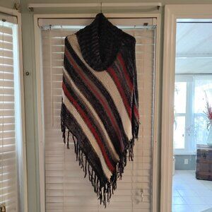 Shawl with cowl neck and fringes along bottom.